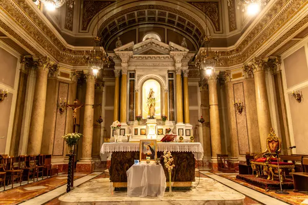 Reggio Calabria - Kalabrien - 05-22-2025: Chiesa del Santo Rosario 'nun sunağı Reggio Calabria' da heykeli, çiçekleri, haçı ve altın mimari unsurları ile yüksek tavan altında.