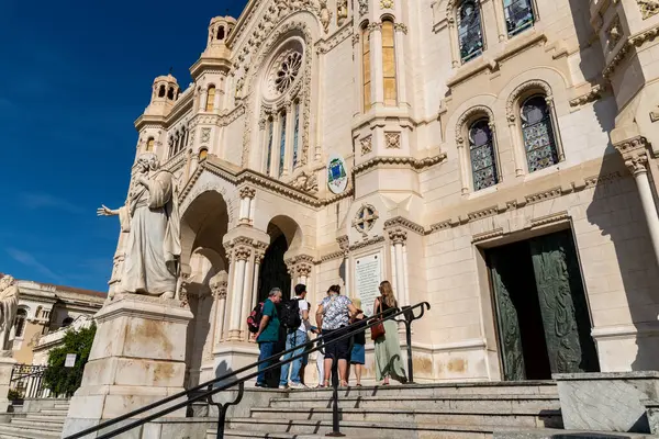 Reggio Calabria - Kalabrien - 05-22-2025: Ziyaretçiler, süslü taş işçiliği, boyalı cam ve dini heykellerle Reggio Calabria Katedrali 'nin önündeki basamaklarda duruyorlar.