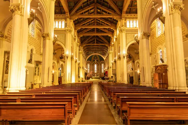 Reggio Calabria - Kalabrien - 05-22-2025: Reggio Calabria Katedrali 'nin iç manzarası ahşap sıralar, kemerli kolonlar, avizeler ve uzak sunakla süslü tavanlar gösteriyor.