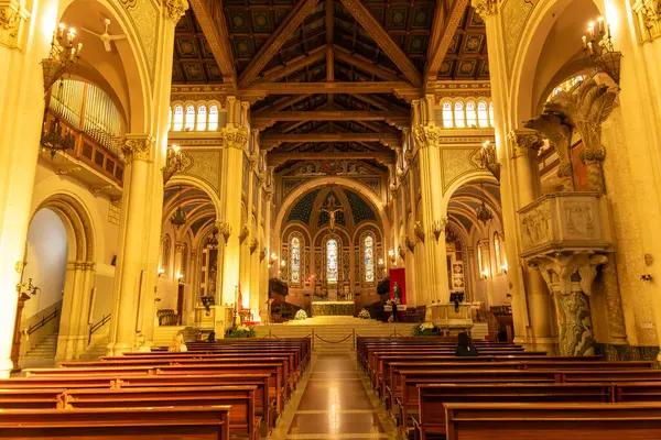 Reggio Calabria - Kalabrien - 05-22-2025: Reggio Calabria Katedrali 'nin iç manzarası ahşap sıralar, kemerli kolonlar, avizeler ve uzak sunakla süslü tavanlar gösteriyor.