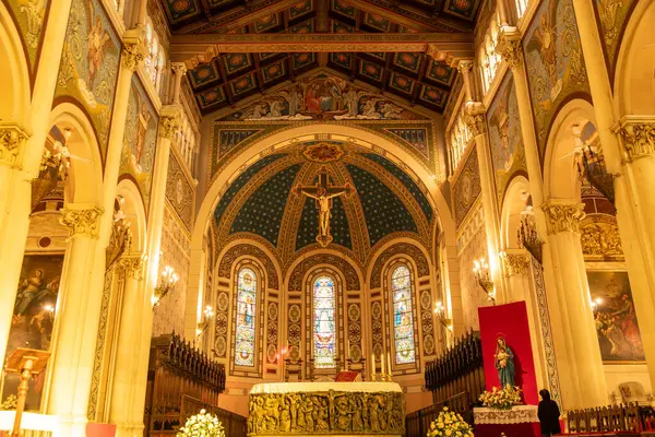 Reggio Calabria - Kalabrien - 05-22-2025: Oyma ön, haç ve zengin dekore edilmiş katedralin renkli camlı pencereleriyle sunağın ön görüntüsü.