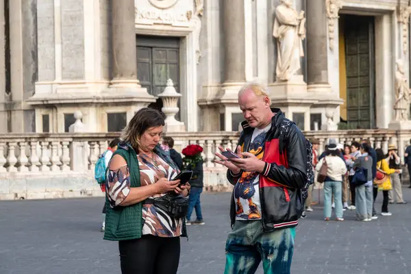 Catania, Sizilien - İtalya - 04-15-2025: Diğer insanlar arka planda toplanırken, Sicilya 'nın Catania kentindeki SantAgata Katedrali önünde iki turist ayakta duruyor.