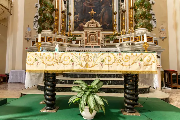Tropea - Kalabrien - İtalya - 05-30-2025: Tropea, Calabria 'da Chiesa del Gesu' da süslü süslemeleri ve altın şamdanları olan bir sunak, bitkiler ve dezenfektan görünür..