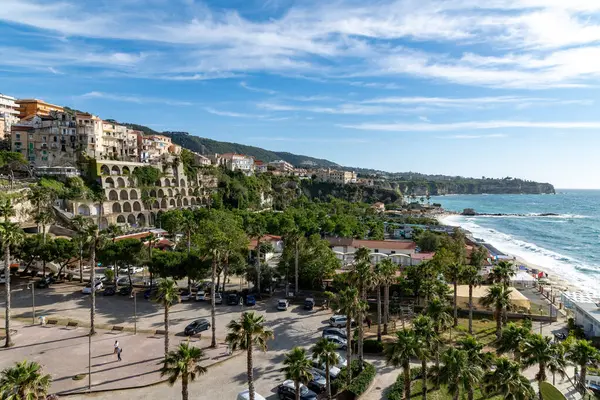 Tropea - Kalabrien - İtalya - 05-30-2025: Güney İtalya 'nın Calabria kentindeki Tropea kıyı kasabası, kayalık binalar, plaj, park edilmiş arabalar ve Tyrhenian Denizi manzarası.