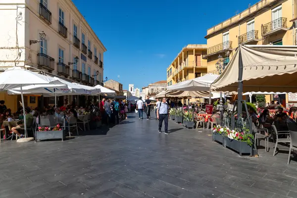 Pizzo - Kalabrien - İtalya - 06-02-2025: Pizzo, Calabria, İtalya 'da güneşli bir günde insanların yemek yediği açık hava restoranları ve sokak kafeleri, tarihi binalarla çevrili.