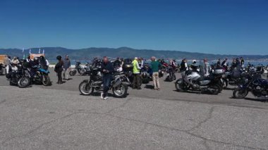 Reggio Calabria seçkin beyefendiler motosikletle geziyorlar ve insanlar güneşli bir günde kamera yavaşça sağa dönerken bir araya geliyorlar..