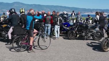 Motosikletçiler, Reggio Calabria 'daki seçkin beyefendiler gezisinde kalabalığın önünden geçerken yolun her iki tarafından da izleyen insanlar vardı..