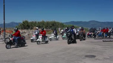 Motosikletçiler Reggio Calabria 'ya katılıyorlar. Seçkin beyefendiler at sürerken, bayraklarını sallayarak ve sergiliyorlar..