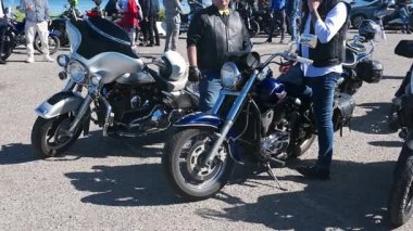 Soldan sağa bir pan, Reggio Calabria şehir merkezinde süren seçkin beyefendiler arasında park etmiş motosikletleri ve bekleyen binicileri gösteriyor..