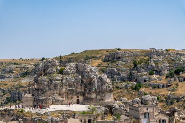 Matera - Basilikata - Italien - 06-16-2025: Tourists visit a rock-carved church structure in Matera, located in the Basilicata region of southern Italy, on a sunny summer day.