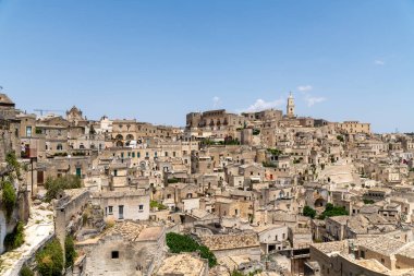 Matera - Basilikata - Italien - 06-16-2025: A panoramic view of the historic city of Matera, Italy, showing densely packed stone buildings under a clear blue sky on a sunny day.