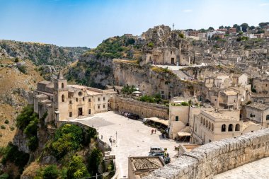 Matera - Basilikata - Italien - 06-16-2025: View of the historic church square in Matera, Basilicata, Italy, with cave dwellings carved into the rocky hillside and stone houses.