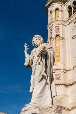 Reggio Calabria Katedrali 'nin önündeki mermer heykel, elinde tomar tutan ve mavi gökyüzüne işaret eden sakallı bir figürü gösteriyor..