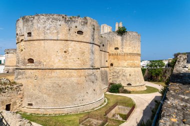Otranto 'daki Aragon Kalesi' nin devasa yuvarlak taş kuleleri. Gün ışığı altında duvarları ve avlu binaları var..