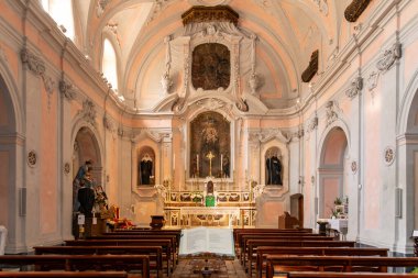Amalfi - Kampanien - Italien - 07-04-2025: Chiesa di S. Benedetto 'nun sunağı, ahşap bankları, heykelleri ve ön planda açık bir ayin kitabı bulunan iç manzarası.