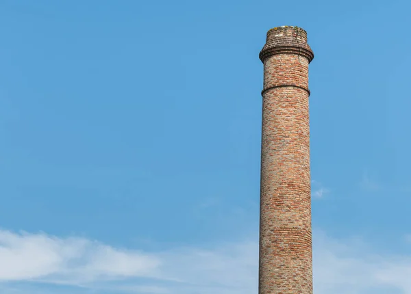old abandoned fireplace made with red bricks on blue sky in Spain