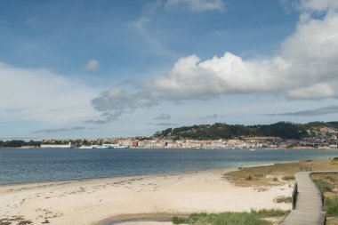 Galiçya 'nın arka planında Cangas de Morrazo kasabası bulunan Rodeira plajı