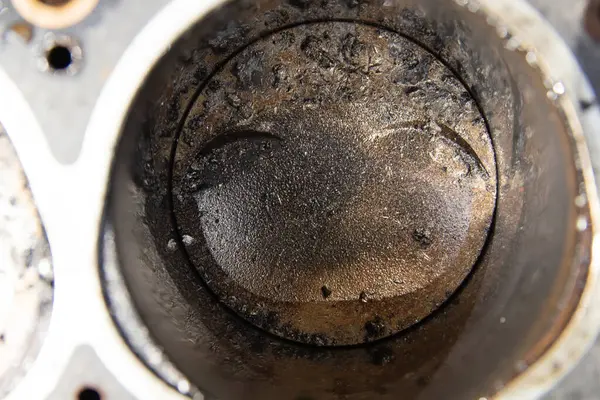 close-up of a damaged car engine piston, the cause of failure is a broken timing belt