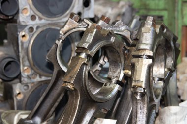 Bir araba motorunun çubuklarını parçalanmış bir motorun arka planına bağlamak