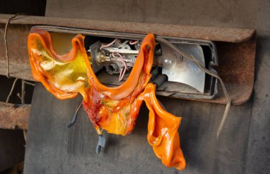 Hasarlı ve erimiş araç stop lambası, bozulmuş plastik aşırı ısı gösteriyor. Küresel ısınmanın sonuçları.