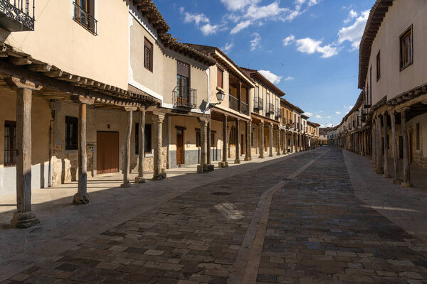 AMPUDIA, SPAIN - MARCH 26, 2021: Streets with a traditional Castilian architecture with its houses with arcades in Ampudia, Palencia, Castilla y Leon, Spain.