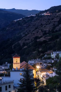 CAPILEIRA, GRANADA - SEPTEMBER 01, 2020: Alpujarra Bölgesi 'nde geceleri Pampaneira beyaz köyünün manzarası Capileira ve Sierra Nevada dağları arka planda. Granada, Endülüs