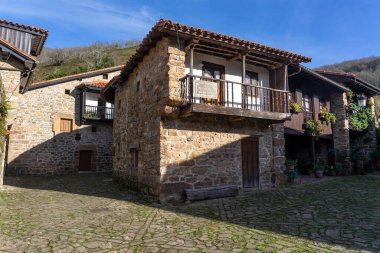 BARCENA MAYOR, İSPAN - 16 HAZİRAN 2022: Güneşli bir günde Cantabria dağlarında geleneksel taş evleri olan Barcena Belediye Başkanı 'nın güzel köyü. Cantabria, İspanya.