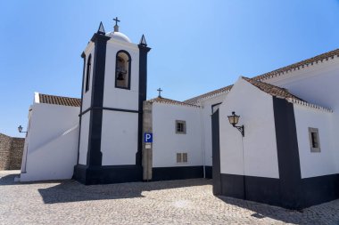 Aldeia Nova köyünün güzel kilisesi ve meydanı güneşli bir günde tipik beyaz cepheli, Algarve bölgesi, Portekiz