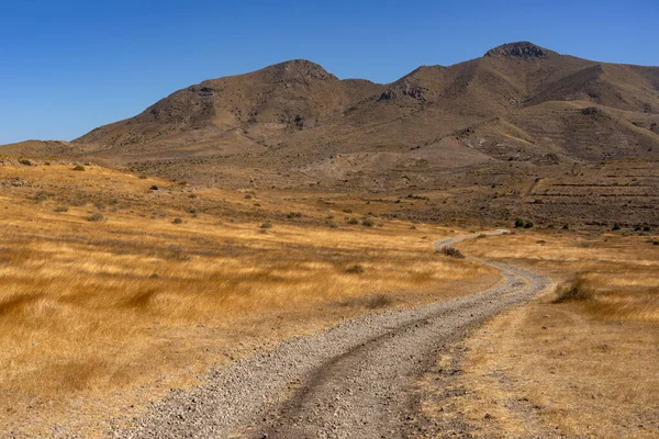 Panoramic view of of mountains with a dirt road in the Gata Cape Natural Park coast. Almera, Andalucia, Spain.