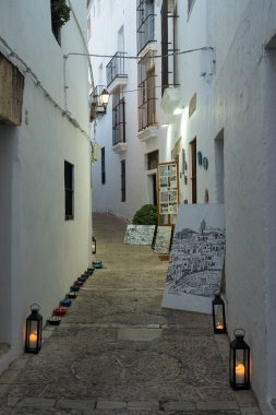 VEJER DE LA FRONTERA, İspanya - 08 Temmuz 2022: Alacakaranlık, Cadiz, Endülüs, İspanya 'daki beyaz güzel Vejer de la Frontera köyünün tarihi merkezinde güzel bir cadde