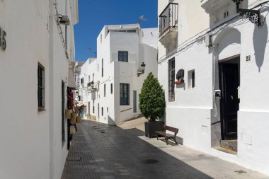 VEJER DE LA FRONTERA, İSPA - 08 Temmuz 2022: Güneşli bir günde, İspanya 'nın Endülüs kenti Cadiz' de, beyaz güzel Vejer de la Frontera köyünün tarihi merkezinde güzel bir cadde