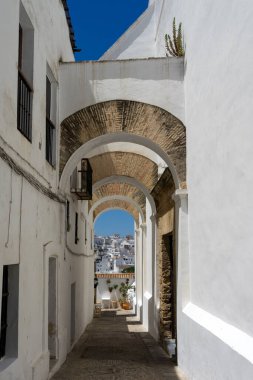 VEJER DE LA FRONTERA, SPAIN - JULY 08, 2022: Arches of the Jewish quarter in the historical center of the white beautiful village of Vejer de la Frontera in a sunny day, Cadiz province, Andalusia, Spain
