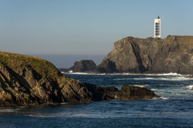 Punta Frouxeira lighthouse with the cliffs in the Rias Altas touristic area of Galicia at sunset, Valdovino, Meiras, Spain. clipart