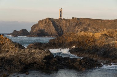 Punta Frouxeira lighthouse with the cliffs in the Rias Altas touristic area of Galicia at sunset, Valdovino, Meiras, Spain. clipart