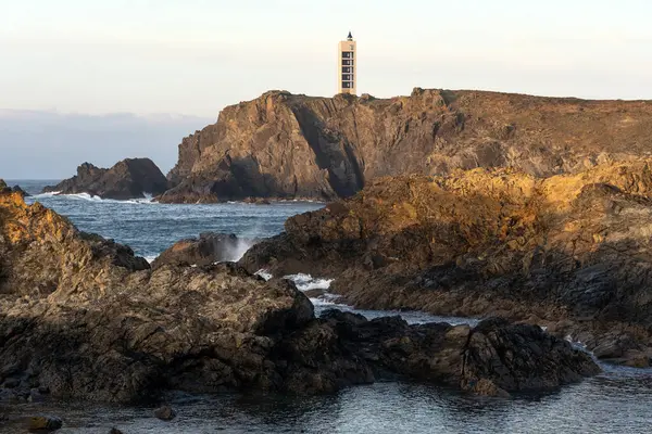 Günbatımında Galiçya 'nın Rias Altas turistik bölgesinde kayalıkları olan Punta Frouxeira deniz feneri, Valdovino, Meiras, İspanya.
