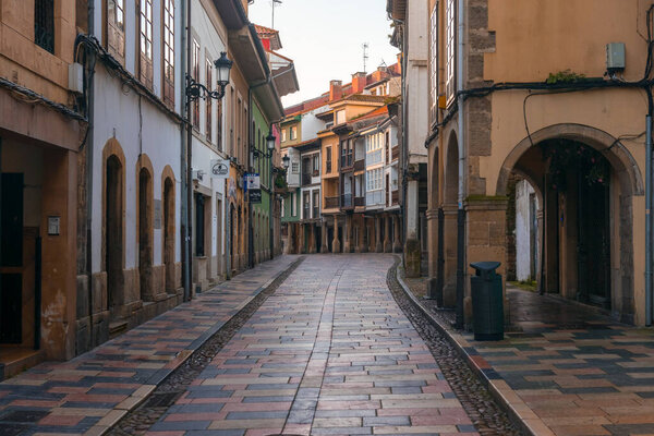 AVILES, SPAIN - FEBRUARY 11, 2023: Rivero street in the old town of the beautiful city of Aviles with its historic buildings with arcades, Asturias, Spain.