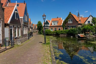 Güneşli bir günde tipik evleri olan Volendam 'ın güzel balıkçı köyü. Hollanda.