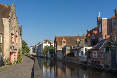 BRUGGE, BELGIUM - 07 Temmuz 2023: Belçika 'nın güzel Brugge şehrinin eski bir kasabası olan Langerei Caddesi, renkli tarihi cepheleri kanala yansıdı..