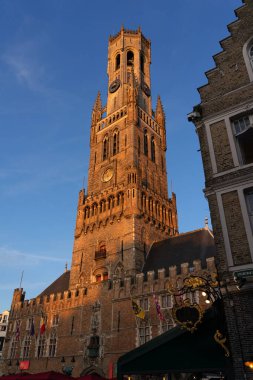 BRUGGE, BELGIUM - 06 Temmuz 2023: Belçika 'nın güzel şehri Brugge' un Grotemarkt Meydanı 'ndaki Belfort Kulesi, gün batımında.