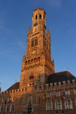 BRUGGE, BELGIUM - 06 Temmuz 2023: Belçika 'nın güzel şehri Brugge' un Grotemarkt Meydanı 'ndaki Belfort Kulesi, gün batımında.