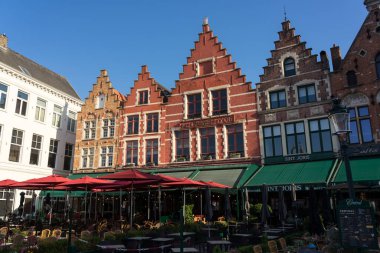 BRUGGE, BELGIUM - 07 Temmuz 2023: Güneşli bir günde Belçika 'nın güzel Brugge kentinin eski kasabasındaki Grotemarkt Meydanı' nın güzel binaları.