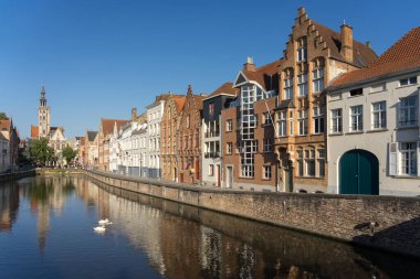 BRUGGE, BELGIUM - 07 Temmuz 2023: Belçika 'nın güzel Brugge kentindeki Spiegelrei kanalı, renkli tarihi cepheleri kanala ve arka planda Jan van Eyckplein meydanına yansıdı.