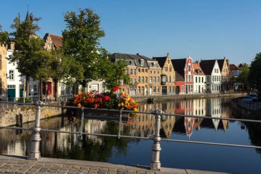 BRUGGE, BELGIUM - 07 Temmuz 2023: Belçika 'nın güzel Brugge şehrinin eski bir kasabası olan Langerei Caddesi, renkli tarihi cepheleri kanala yansıdı..