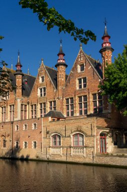 BRUGGE, BELGIUM - 07 Temmuz 2023: Groenerei kanalı ve tarihi binalar güneşli bir günde Belçika 'nın güzel Brugge kentinin eski kasabasındaki suya yansıdı.