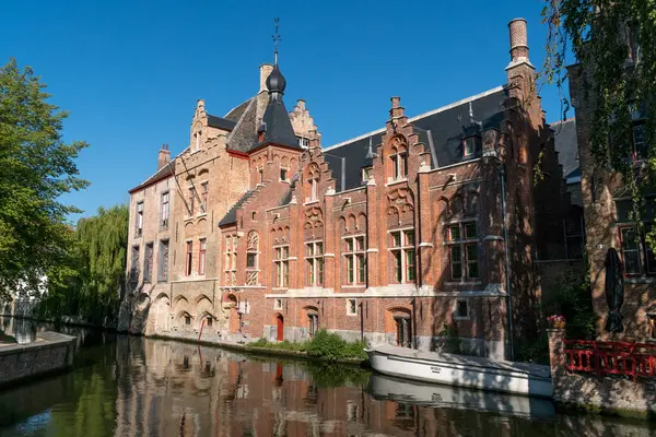 stock image BRUGGGE, BELGIUM - JULY 07, 2023: Wharf on the canal since Dijver park reflected on the water in the old town of the beautiful city of Brugge in Belgium.