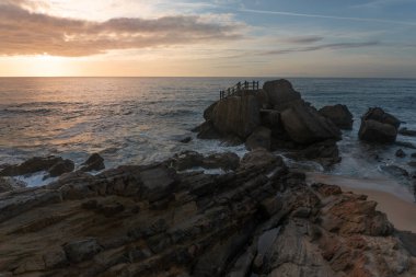 Santa Cruz plajı ünlü doğal kaya oluşumuyla gün batımında, Portekiz.