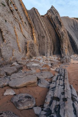İspanya 'nın kuzeyinde Cantabria' da gün batımında Portio plajında renkli kaya oluşumları (Flysch).