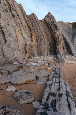 İspanya 'nın kuzeyinde Cantabria' da gün batımında Portio plajında renkli kaya oluşumları (Flysch).