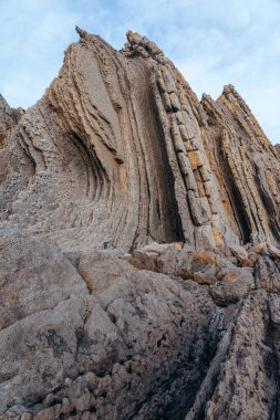 İspanya 'nın kuzeyinde Cantabria' da gün batımında Portio plajında renkli kaya oluşumları (Flysch).