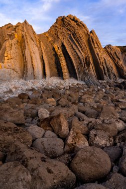 İspanya 'nın kuzeyinde Cantabria' da gün batımında Portio plajında renkli kaya oluşumları (Flysch).